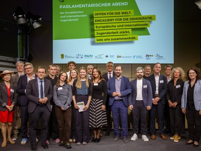 Gruppenbild der Teilnehmer:innen des 11. Parlamentarischen Abends der Europäischen und Internationalen Jugendarbeit auf der Bühne.