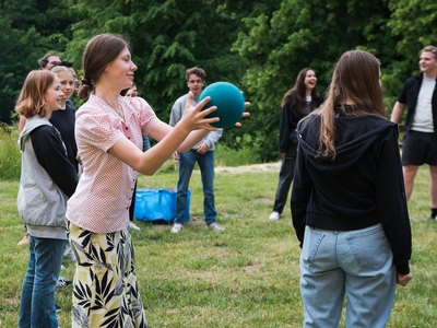 Junge Menschen spielen in einem Park mit einem Ball.